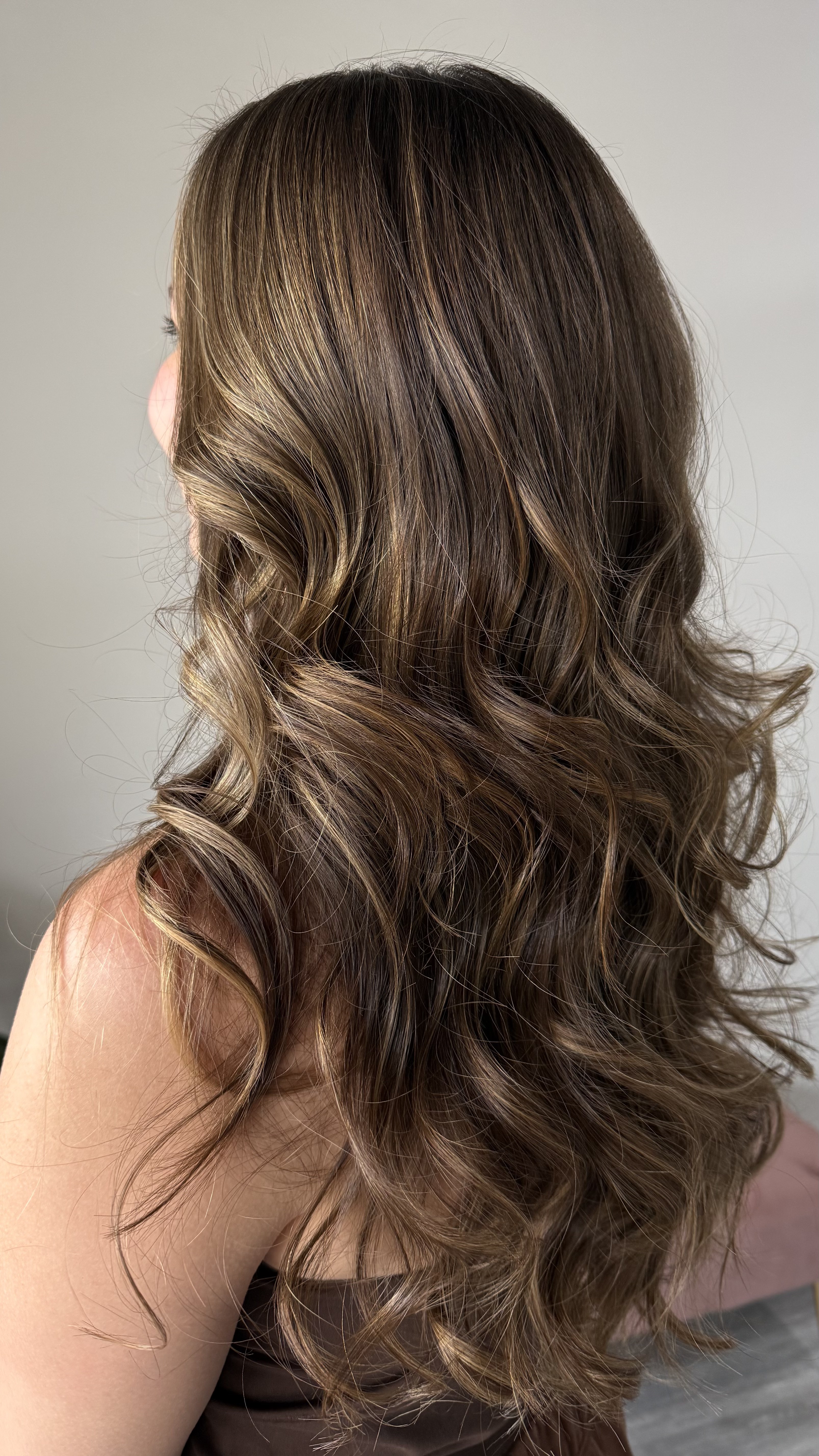 Voluminous bronde waves with hand-painted highlights and rounded blowout finish