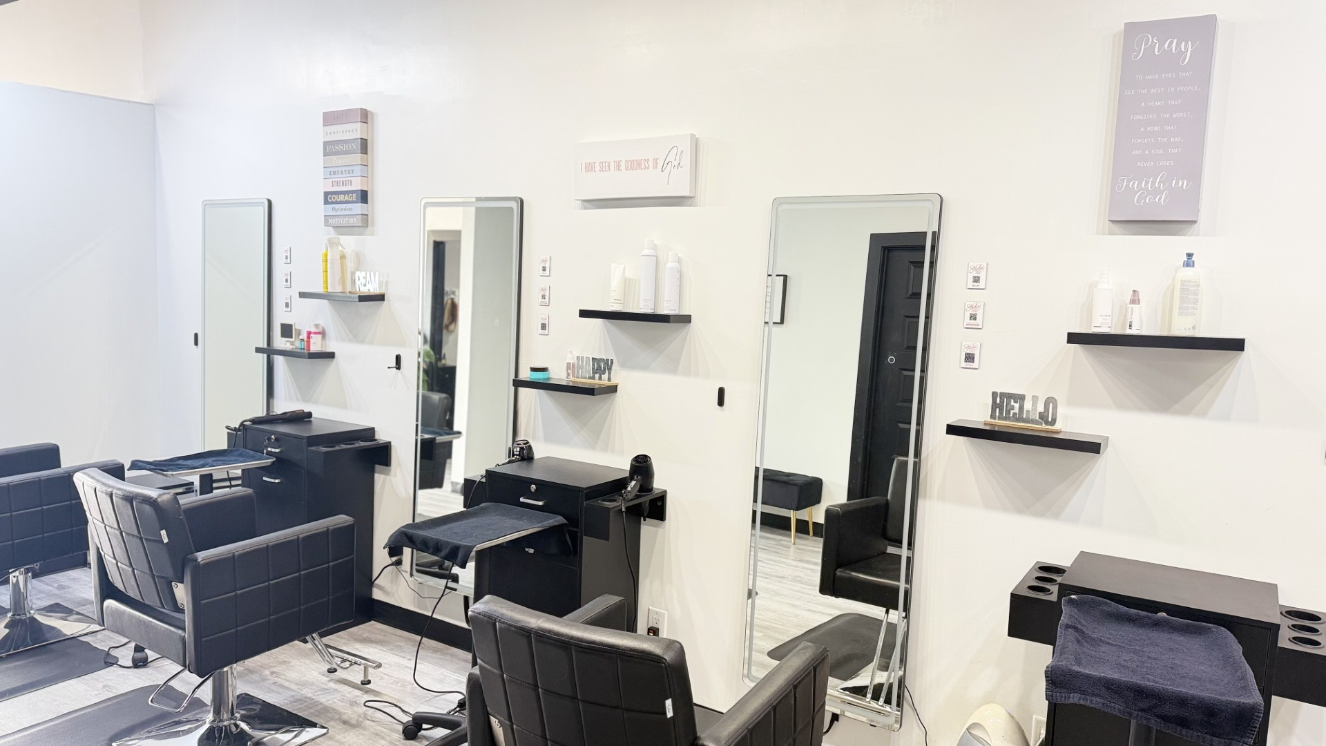 Styling stations with black chairs and full-length mirrors inside Studio 3.1.6 Salon